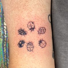 a ladybug tattoo on the left arm with six ladybugs all over it