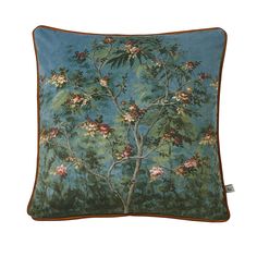 a blue pillow with an image of a tree and flowers on the front, against a white background