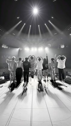 a group of people standing on top of a stage with their arms in the air