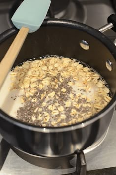 the food is being cooked in the pot on the stove top with a spatula