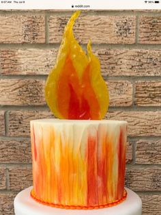 a multi - colored cake with an orange and yellow flame on top