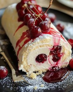 a piece of cake on a plate with cherries