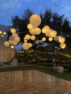 an outdoor dance with paper lanterns hanging from the ceiling and string lights on the ground