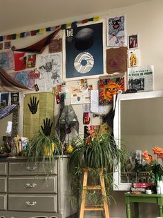 a room with many pictures and plants on the wall