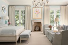 a bedroom with blue walls and white furniture in it, along with a chandelier hanging from the ceiling