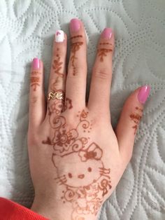 a woman's hand with henna tattoos on her left and the word hello kitty painted on it