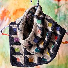 a multicolored scarf hanging from a hook on a colorful tie - dyed background