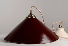 a brown and white lamp sitting on top of a table next to a light bulb