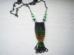 A bead woven amulet pouch.. Made with Japanese Delica beads in rich silver lined green, light topaz, and iridescent deep purple, with green cat's eye bead accents, and an antiqued bronze chain. Lovely to carry a crystal, amulet, scented cotton.. 28" in length, with a pendant drop of another 3". There is no clasp on this necklace - just pops over the head. Green Beaded Rectangular Necklace, Green Rectangular Beaded Necklace, Green Rectangular Beaded Necklace Gift, Rectangular Green Beaded Necklace For Gift, Handmade Green Amulet Beaded Necklace, Green Beaded Amulet Necklace, Amulet Style Beaded Necklace With Spacer Beads As Gift, Unique Green Beaded Necklaces With Tiny Beads, Unique Green Beaded Necklace With Tiny Beads