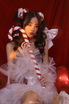 a woman in white dress holding a candy cane