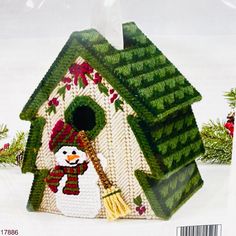 a green birdhouse with a snowman in it