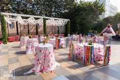 tables and chairs covered with colorful cloths are set up for an outdoor wedding reception