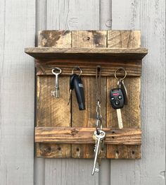 a wooden key holder with keys hanging from it's sides and attached to the wall