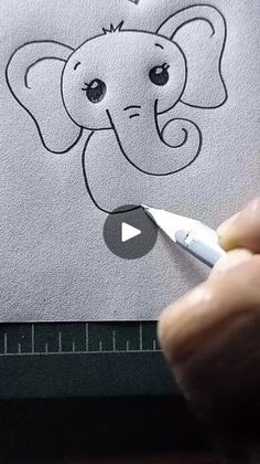 someone is drawing an elephant on paper with a marker and pen, while the image appears to be being drawn