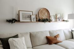 a living room with white couches and pictures on the wall above them, along with other decorations