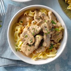 two bowls filled with pasta and meat covered in gravy