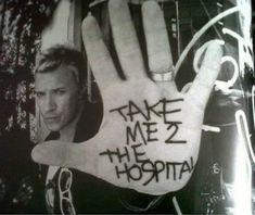 a man holding up a hand with the words take me to the hospital written on it