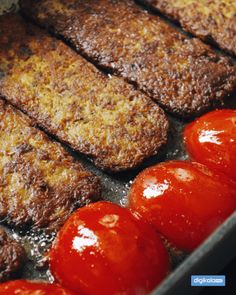 some meat and tomatoes cooking in a pan