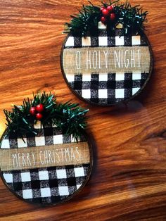 two christmas wreaths on top of a wooden table with the words merry christmas written on them