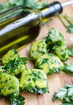 a bottle of olive oil sitting on top of a cutting board next to cut up vegetables