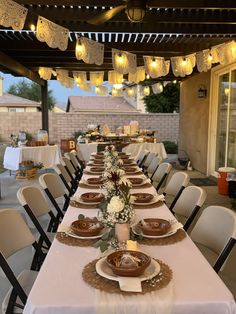 an outdoor dining area with tables and chairs set up for a formal dinner or party