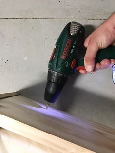 a person using a cordless drill to cut wood