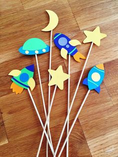 there are some cupcake toppers that look like rocket ship and spaceships on sticks