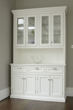 a white china cabinet with glass doors and drawers