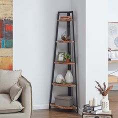 a living room filled with furniture and a tall wooden shelf next to a wall mounted painting