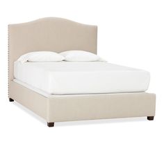 a bed with white linens and pillows on it's headboard, in front of a white background