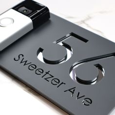 an electronic device sitting on top of a black sign that says sweeter avg