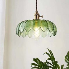 a green glass light hanging from a ceiling