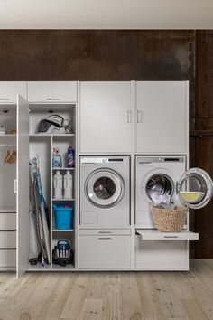 a washer and dryer in a room with wood flooring, cabinets and shelves