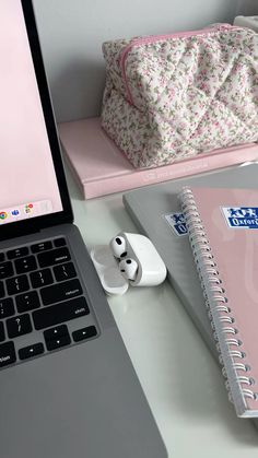 an open laptop computer sitting on top of a desk next to a notebook and mouse