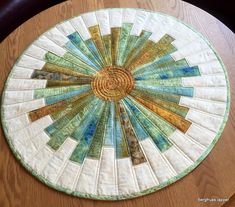 a table top with a circular design on the center and bottom part of it, sitting on a wooden table