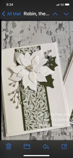 two cards with white flowers and green leaves on them