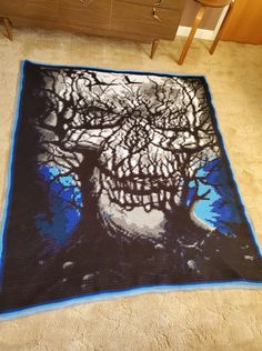 a blue and black blanket with a tree on it