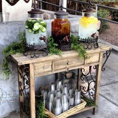 an old wooden table topped with jars filled with drinks