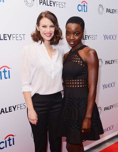 two women standing next to each other on a red carpet at an event in front of a palefest sign