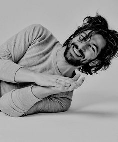 a man is laying on the floor with his arms spread out and smiling at the camera