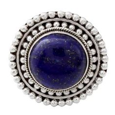 Glistening like a clear sky at dusk a circular gemstone of precious lapis lazuli sits atop a sterling silver crown. Neeru Goel of India presents this sterling silver cocktail ring reminiscent of a royal sunset on a summer evening. Celestial Blue Cabochon Jewelry, Blue Celestial Cabochon Jewelry, Celestial Style Blue Cabochon Jewelry, Round Lapis Lazuli Cabochon Rings, Bohemian Sapphire Round Jewelry, Lapis Lazuli Cabochon Rings, Stamped 925 Round Lapis Lazuli Jewelry, Sapphire Gemstones In Sterling Silver, Round Lapis Lazuli Jewelry With Natural Stones