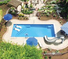 an aerial view of a swimming pool surrounded by trees