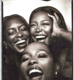 three women laughing together with their mouths open