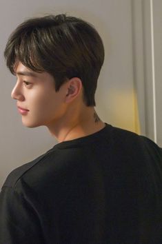 a young man wearing a black shirt looking off into the distance