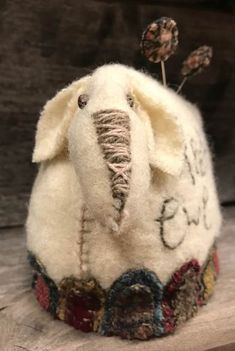 an elephant is sitting on top of a piece of wood and has flowers in its trunk