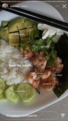 a white plate topped with rice, cucumber and shrimp next to chopsticks