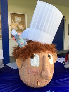 a pumpkin with a chef's hat on it sitting on top of a table