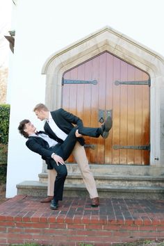 two men in suits and ties are posing for a photo outside the door of a church