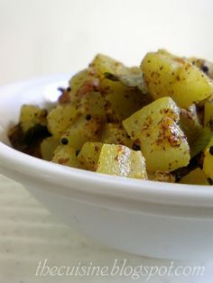 a white bowl filled with cooked potatoes on top of a table