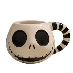 a ceramic coffee mug with black and white stripes on the inside, decorated like a jack skellingy face